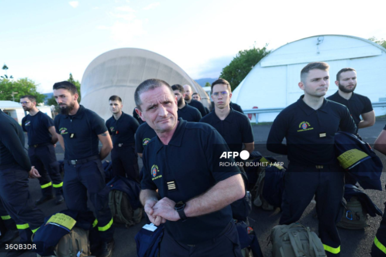 Members of the French Civil protection and French firefighters walk on the tarmac following their landing aboard the A440M military aircraft, as part of an emergency response to bring aid to the small French Indian Ocean territory of Mayotte