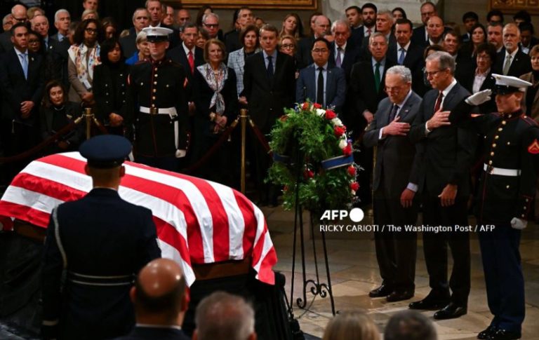 Senate Democratic leader Chuck Schumer ((L) and Senate Majority Leader John Thune (R) present a wreath during a ceremony honoring the late former US President Jimmy Carter in the Rotunda of the US Capitol, where he will lie in state, in in Washington, DC, on January 7, 2025