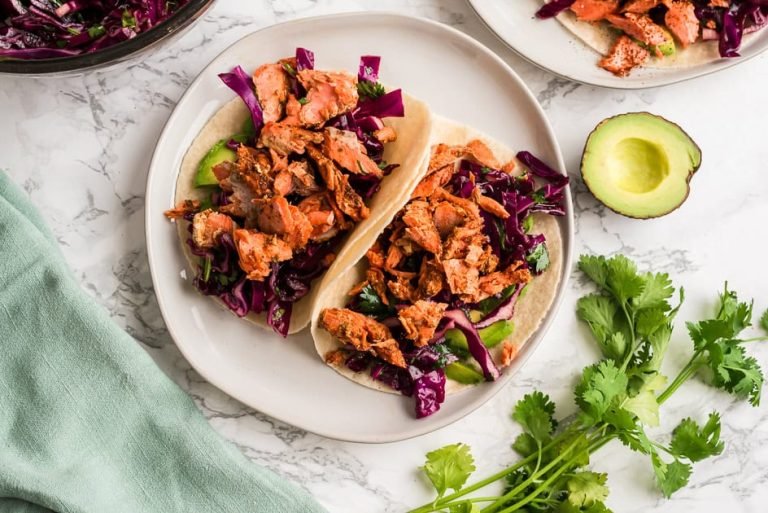 Ingredients to make chipotle salmon tacos on a marble countertop.