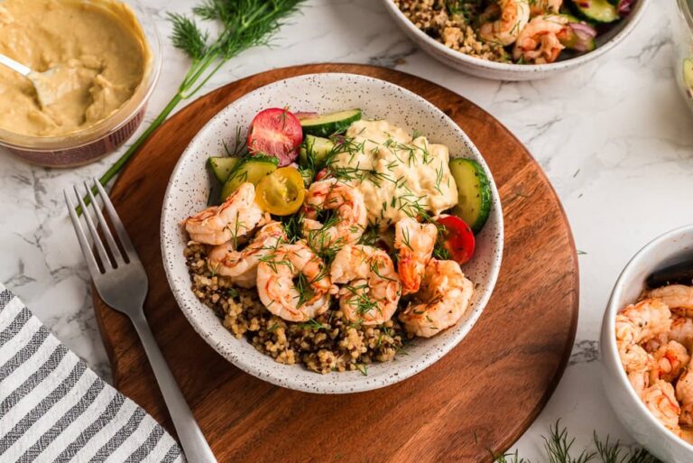 Greek shrimp bowl with a cucumber tomato salad on a wooden bowl.