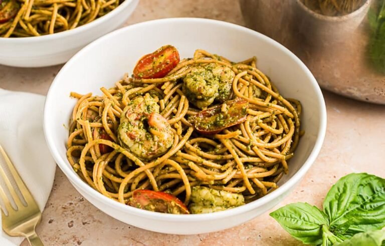 Pesto shrimp pasta in a white bowl.