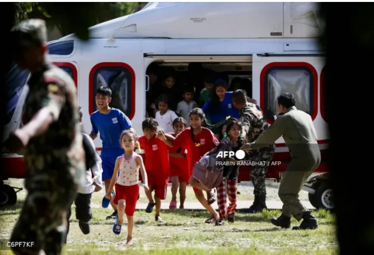 Rescued children disembark from a helicopter at an army camp following flash floods, in Battar Bazar town in Nepal