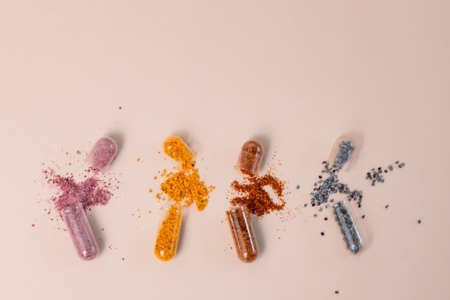 A selection of colourful supplement capsules, tablets, and gummies arranged on a table