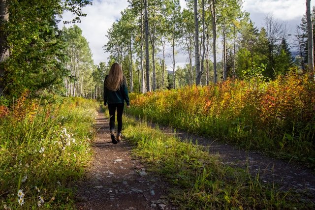 A person walking outdoors for back health